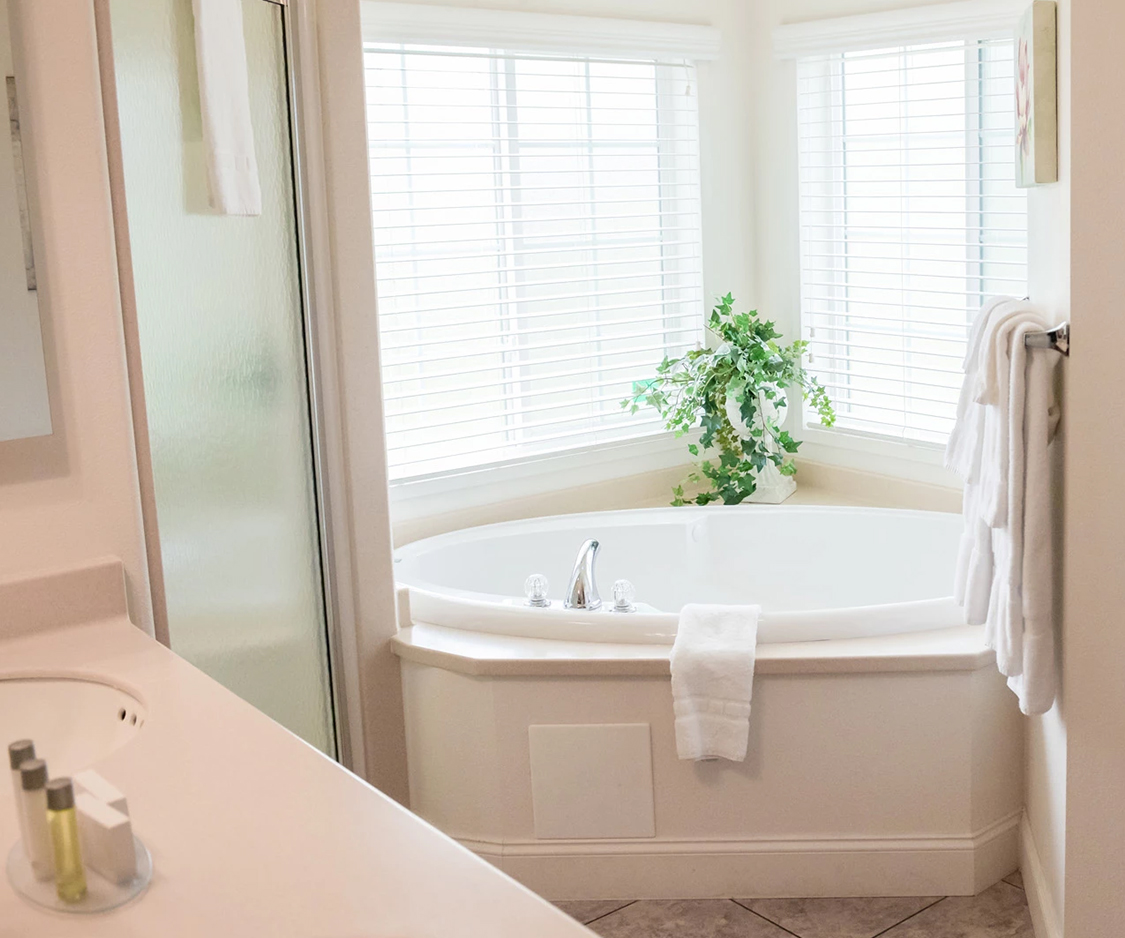 a bathroom with a corner tub and shower