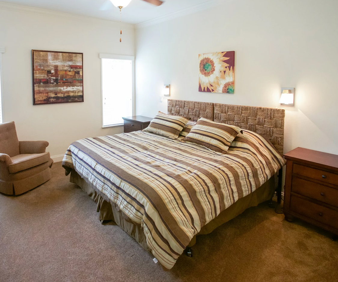 a bed with pillows and a fan in a room