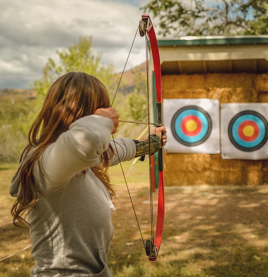 a woman aiming a bow and arrow