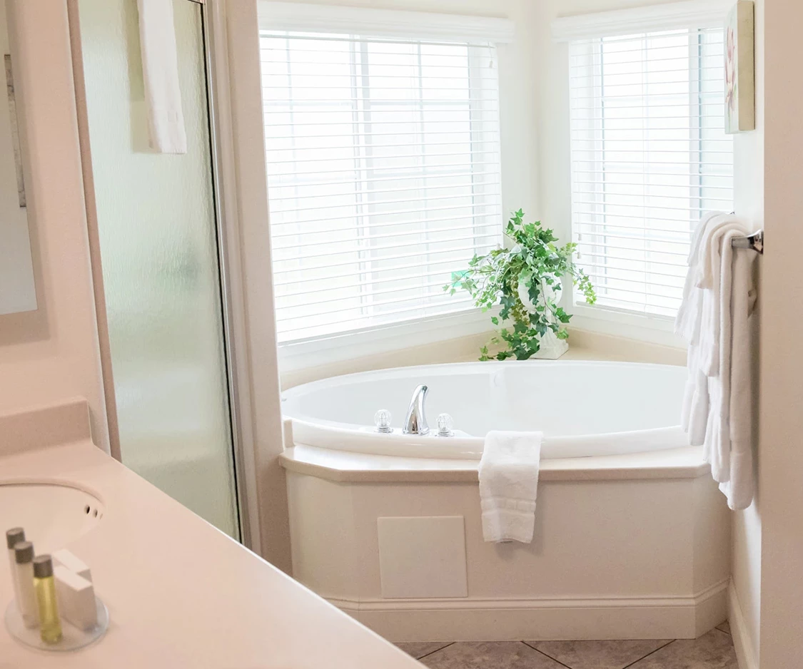 a bathroom with a corner tub and shower