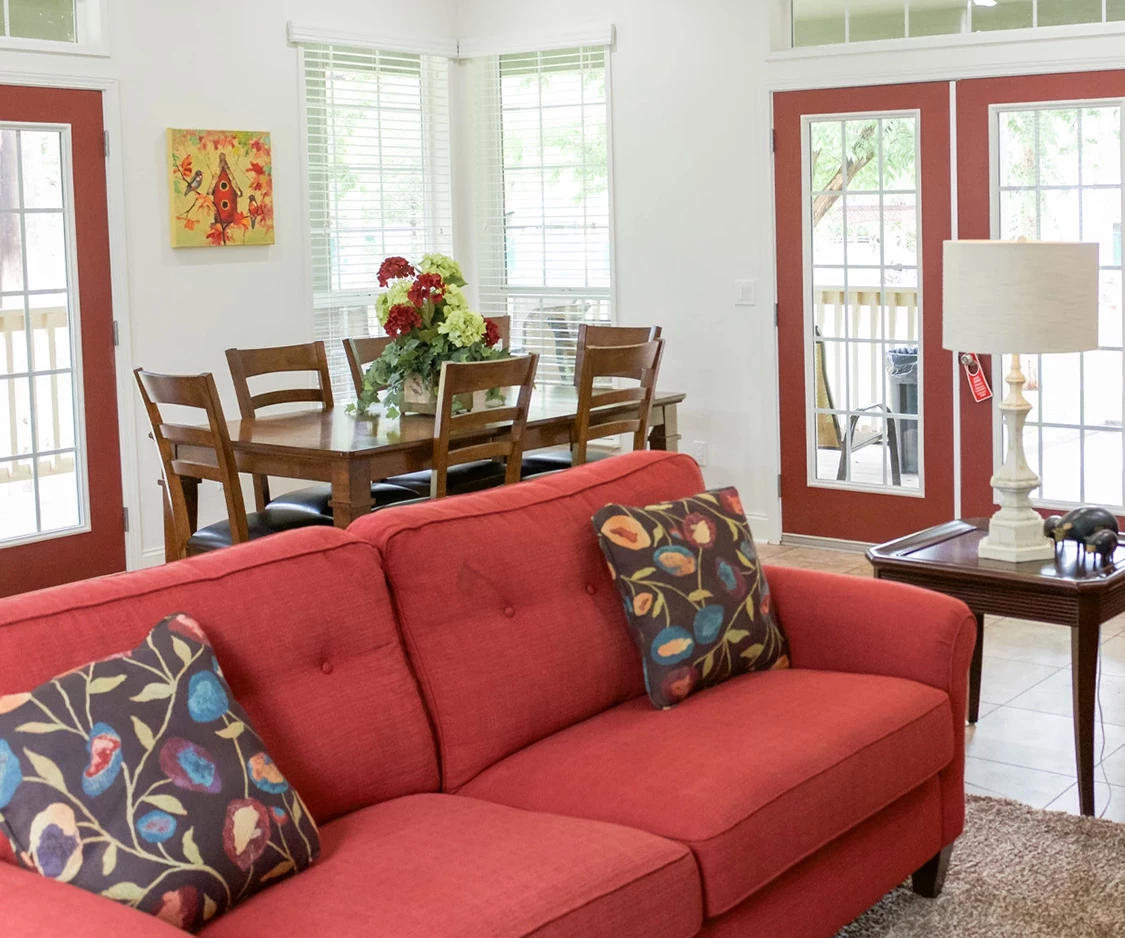 a living room with a red couch and a table