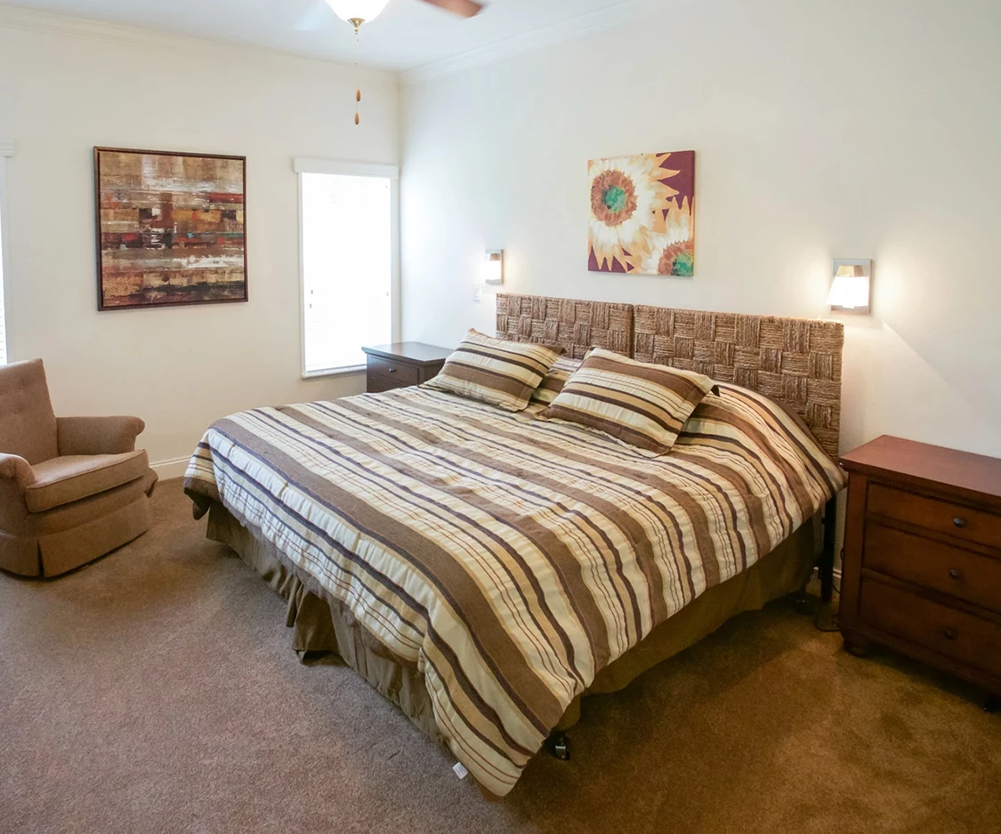 a bed with pillows and a fan in a room