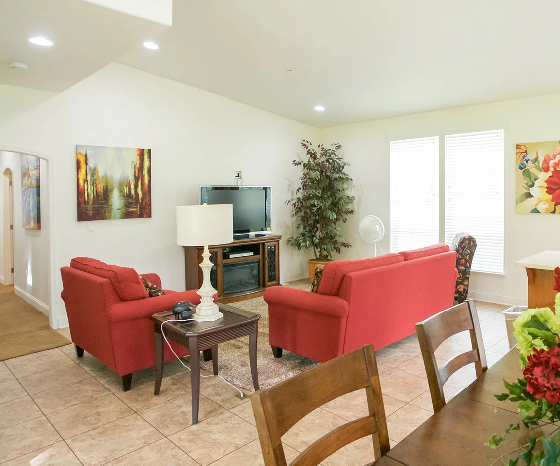 a living room with red couches and a tv