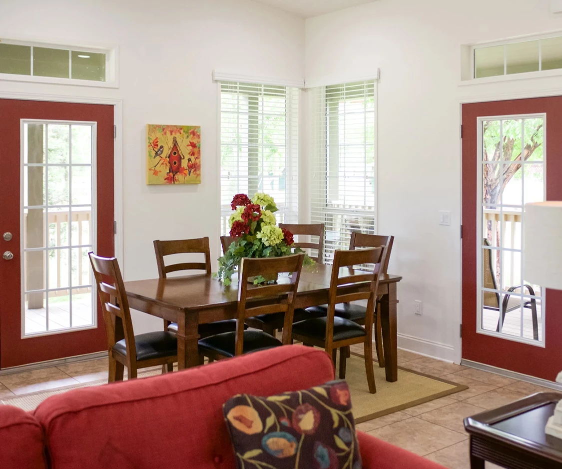 a dining table and chairs in a room with red doors