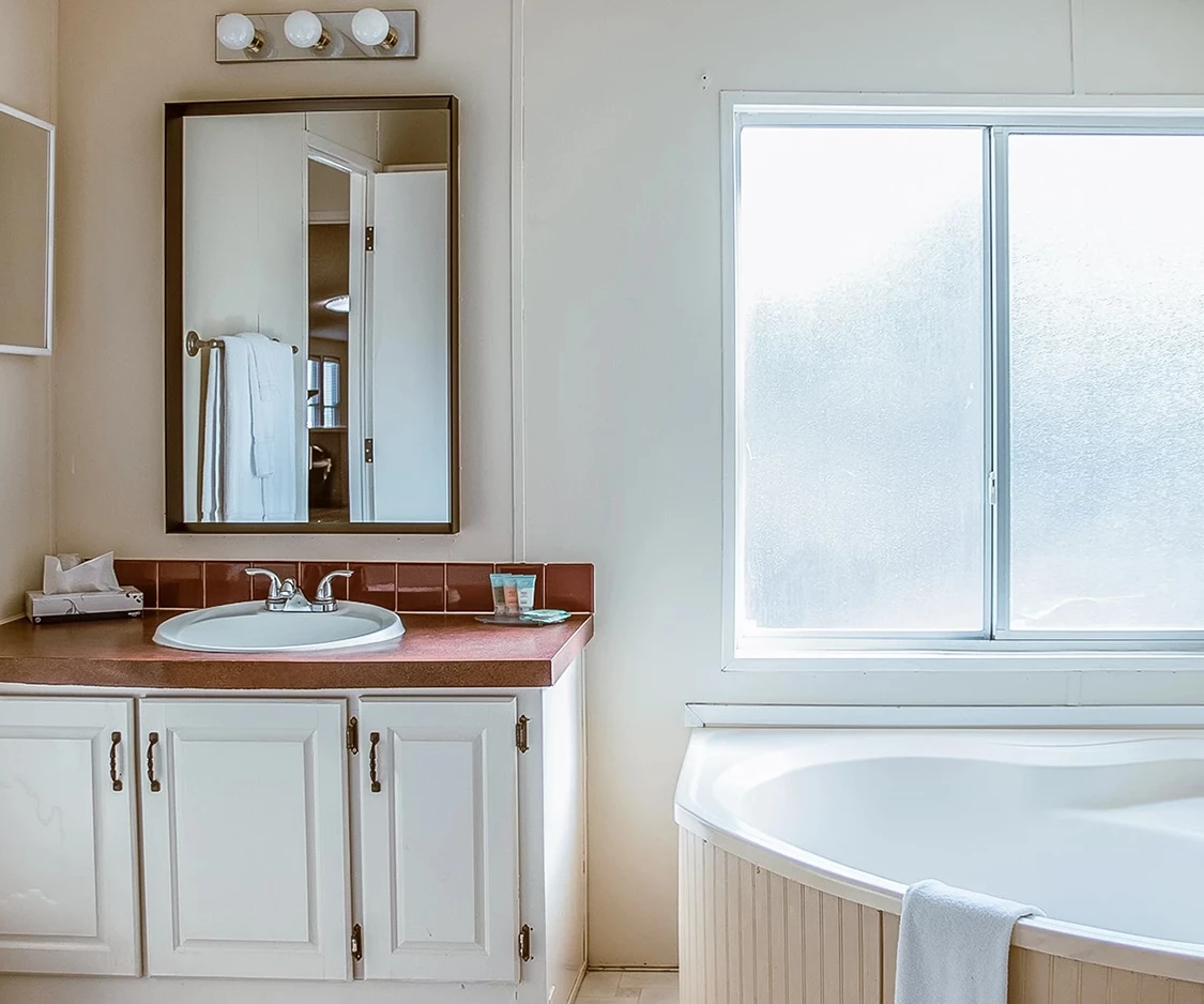 a bathroom with a tub and a mirror